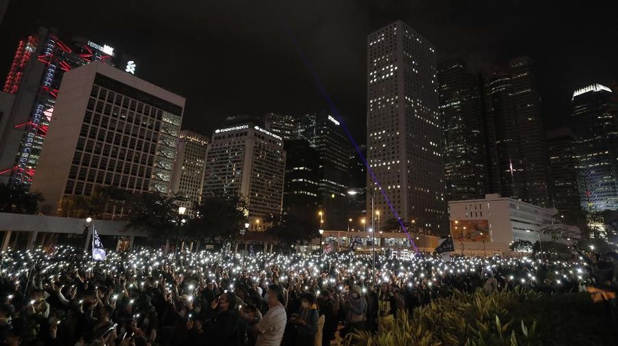 Peserta demonstrasi Hong Kong menyalakan senter dari smartphone.