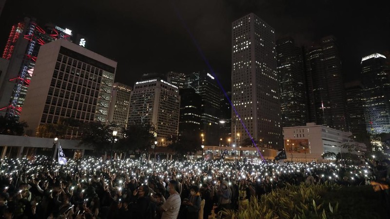 Peserta demonstrasi Hong Kong menyalakan senter dari smartphone.