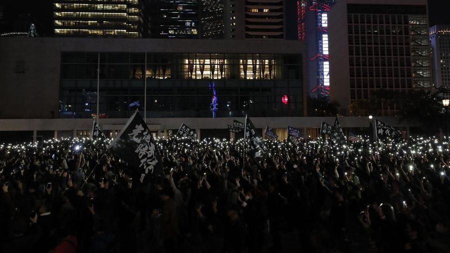Peserta demonstrasi Hong Kong menyalakan senter dari smartphone.