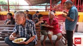 Tampak warga sekitar vihara tengah menikmati menu nasi kuning yang dijual di Warung Makan Podjok Halal vihara. CNNIndonesia/Safir Makki