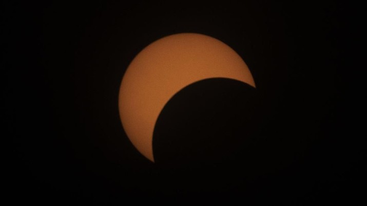 The moon begins to travel a path across the sun during a partial eclipse visible from Bangkok, Thailand, Thursday, Dec. 26, 2019. (AP Photo/Sakchai Lalit)