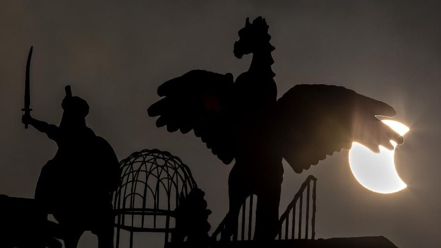 A partial solar eclipse happens behind statues in Islamabad, Pakistan, Thursday, Dec. 26, 2019. The last solar eclipse of 2019 was witnessed in Pakistan along with several other countries. (AP Photo/B.K. Bangash)