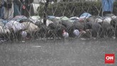 Massa aksi Bela Uighur menggelar salat ashar berjamaah di lokasi demonstrasi, Kedutaan Besar Republik Rakyat China di Jakarta. Salat dilakukan di badan jalan, di bawah hujan deras yang mengguyur ibu kota, Jumat (27/12) sore. (CNNIndonesia/Adhi Wicaksono)
