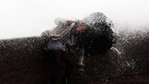 Seorang perempuan coba mempertahankan keseimbangan sementara deburan ombak menerpa tembok pinggiran laut di Biarritz, Perancis bagian Selatan. (AP Photo/Bob Edme)