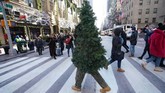 Seorang seniman jalanan bernama Thomas Liberto yang dikenal di media sosial sebagai Mr. Christmas Tree, berjalan di pusat kota New York. (Photo by TIMOTHY A. CLARY / AFP)