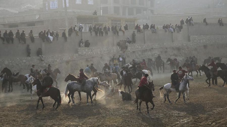 Afghan horse riders compete for the goat during a friendly buzkashi match on the outskirts of Kabul, Afghanistan, Friday, Dec. 27, 2019. Buzkashi is a traditional and the national sport of Afghanistan, where players compete to place a goat carcass into a goal circle. It was banned during the Taliban rule. (AP Photo/Rahmat Gul)