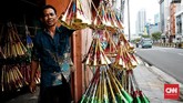 Sukani (46) membuat pluit bambu untuk terompet yang baru dibuatnya untuk perayaan tahun baru di kawasan Glodok, Jakarta Barat, Minggu (24/12/2019). CNN Indonesia/Andry Novelino