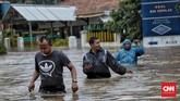 Warga melintas melewati luapan banjir akibat curah hujan tinggi di kawasan Hek, Jalan Raya Pondok Gede, Kramat Jati, Jakarta Timur, 1 Januari 2020. (CNN Indonesia/Bisma Septalisma)