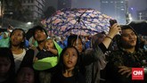 Beberapa warga tampak memakai jas hujan dan payung yang sebelumnya telah mereka siapkan. (CNN Indonesia/Safir Makki).