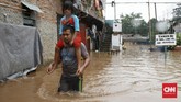 Seorang pria menggendong anak untuk dievakuasi mengungsi di kawasan rumah padat penduduk Rawajati, Kalibata, Jakarta Selatan, 1 Januari 2020. Banjir setinggi 2,5 meter merendam kawasan Rawajati. (CNN Indonesia/Andry Novelino)