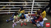 Sekitar pukul 16.15 WIB gerimis turun, beberapa orang berangsur bubar. Penonton yang tadinya menggelar tikar di trotoar pun bergegas membereskan barang bawaannya. Tetapi bagi mereka yang sudah berdiri tepat di depan panggung enggan beranjak dan memilih bertahan. (CNN Indonesia/Adhi Wicaksono).