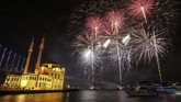Kembang api meledak di atas masjid Mecidiye era Ottoman di alun-alun Ortakoy di atas Selat Bosporus, yang memisahkan Eropa dan Asia, di Istanbul, Rabu, 1 Januari 2020. (AP/Emrah Gurel)