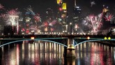Warga menonton kembang api selama perayaan Tahun Baru di dekat gedung-gedung distrik perbankan di Frankfurt, Jerman, Rabu malam, 1 Januari 2020. (AP/Michael Probst)