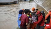 Petugas dan warga melakukan evakuasi saat banjir merendam daerah Cipinang Melayu, Jakarta, 1 Januari 2020. (CNN Indonesia/Adhi Wicaksono)
