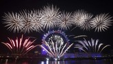 Kembang api meledak di atas kincir London Eye Ferris di tepi Sungai Thames di London, untuk menandai awal tahun baru, Rabu, 1 Januari 2020. (AP/Matt Dunham)