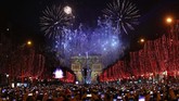 Warga mengabadikan momen kembang api di atas Arc de Triomphe ketika mereka merayakan Tahun Baru di Champs Elysees, di Paris, Prancis, Rabu, 1 Januari 2020. (AP/Christophe Ena)