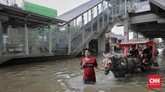 Warga menggunakan kereta kuda untuk melintasi banjir di kawasan sekitar Stasiun LRT Pulomas, Jakarta Timur, 1 Januari 2020. (CNN Indonesia/Adhi Wicaksono)