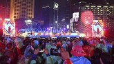 Sejumlah warga mengenakan jas hujan dan menggunakan payung saat menikmati hiburan dalam acara hari bebas kendaraan bermotor (HBKB) atau 'car free night' di kawasan Bundaran Hotel Indonesia. (ANTARA FOTO/Aditya Pradana Putra).