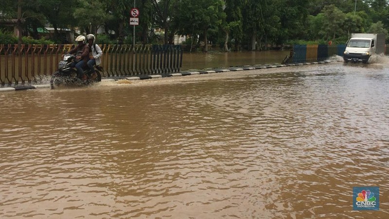Permukaan air Sungai Ciliwung meluap hingga rata dengan permukaan jalan di Pasar Baru. (Depan BPS)