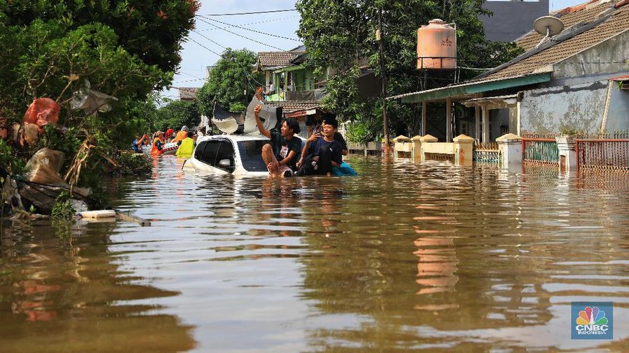 Warga memfoto mobil yang hanyut akibat banjir di Kawasan Ciledug Indah, Tangerang, Kamis (2/1/2020).
