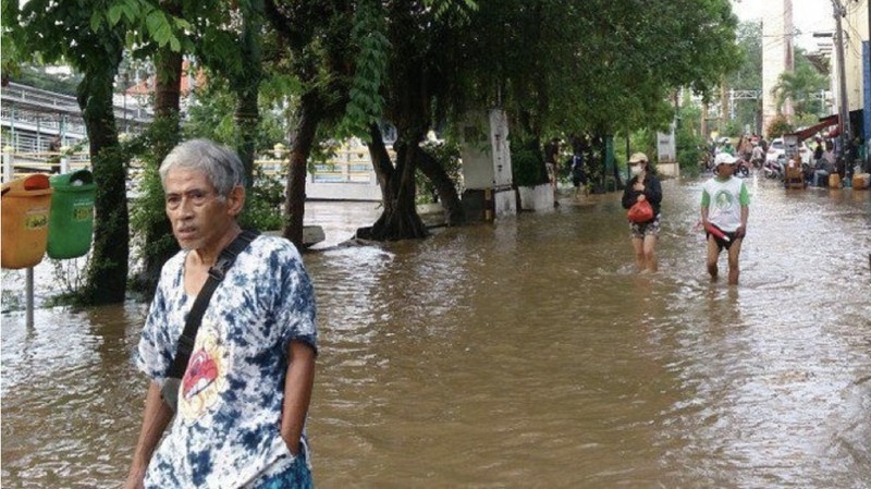 Permukaan air Sungai Ciliwung meluap hingga rata dengan permukaan jalan di Pasar Baru. (Depan BPS)