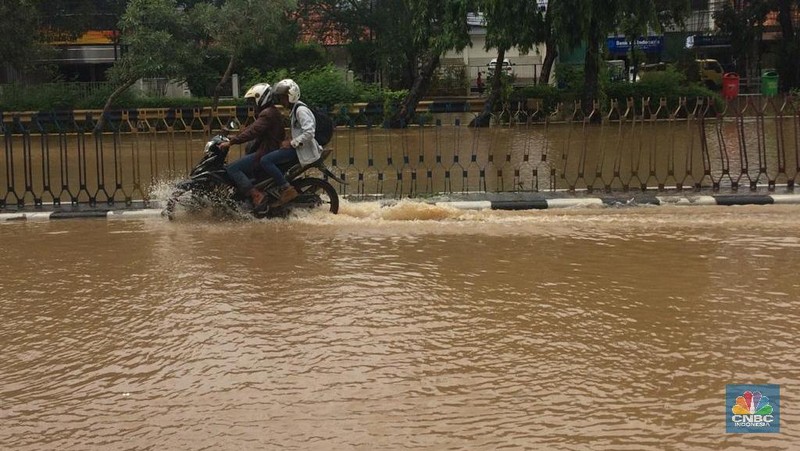 Permukaan air Sungai Ciliwung meluap hingga rata dengan permukaan jalan di Pasar Baru. (Depan BPS)