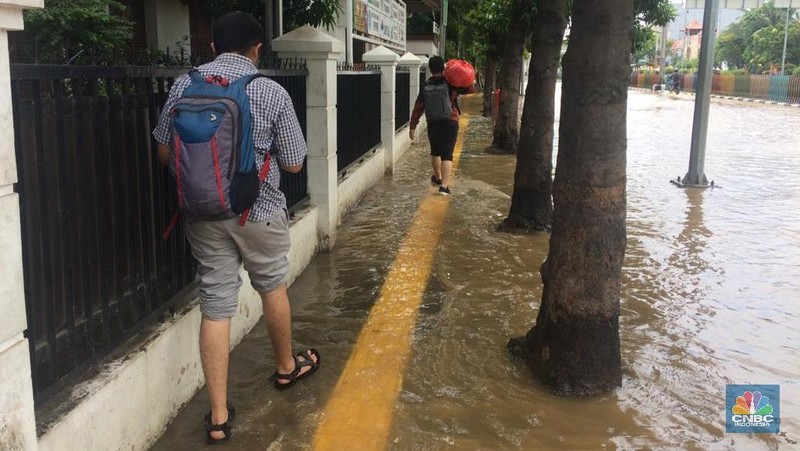 Permukaan air Sungai Ciliwung meluap hingga rata dengan permukaan jalan di Pasar Baru. (Depan BPS)