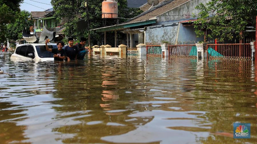 Warga memfoto mobil yang hanyut akibat banjir di Kawasan Ciledug Indah, Tangerang, Kamis (2/1/2020).