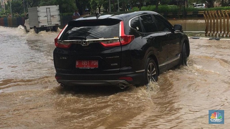 Permukaan air Sungai Ciliwung meluap hingga rata dengan permukaan jalan di Pasar Baru. (Depan BPS)