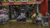 Pekerja membuang air yang masuk ke dalam toko saat banjir menggenangi kawasan Pasar Baru di Jakarta, Kamis (2/1/2020). (ANTARA FOTO/Nova Wahyudi)