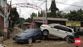 Setelah banjir surut, banyak mobil milik warga saling bertumpuk. Pertanda gelombang air kiriman begitu kuat mengguncang kendaraan yang terparkir. (CNN Indonesia/Adhi Wicaksono)