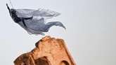 Penari tengah bergelayut di crane, latihan untuk acara Tahun Baru di Circus Maximus, Senin (30/12). (Photo by Alberto PIZZOLI / AFP)