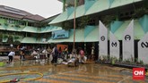 Guru dan murid membersihkan meja dan kursi pascabanjir yang merendam SMA Negeri 8 Jakarta di Bukit Duri, Tebet, Jakarta, Sabtu (4/1). (CNN Indonesia/Adhi Wicaksono)