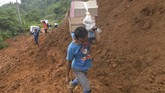 Warga korban longsor membawa logistik menaiki bukit untuk menuju rumah mereka yang terdampak longsor di Sukajaya, Bogor, Jawa Barat, Minggu (5/1/2020). (ANTARA FOTO/Akbar Nugroho Gumay)