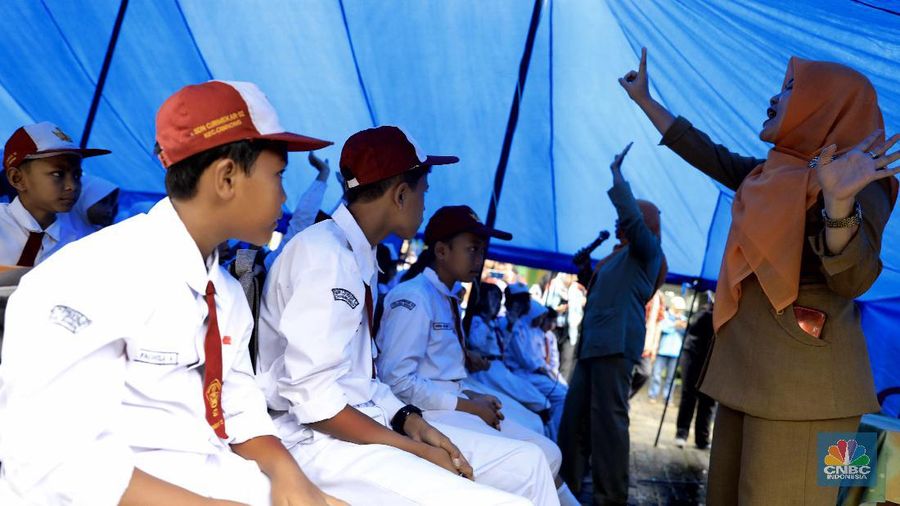Siswa beraktifitas belaja dengan beratap tenda di Sekolah Dasar Negeri (SDN) Cirimekar 02 Cibinong, Kabupaten Bogor, Jawa Barat, Senin (6/1/2020). Sekolah tersebut rusak berat akibat hujan yang mengguyur wilayah Jabodetabek pada 31 Desember 2019 hingga 1 Januari 2020. Pantauan CNBC Indonesia ada lima ruang yang atapnya ambruk dihantam derasnya air hujan. Tiga ruang kelas, satu ruang guru, dan satu ruang komputer. (CNBC Indonesia/Muhammad Sabki)