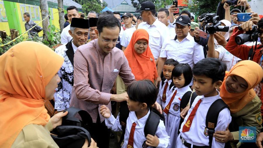 Menteri Pendidikan dan Kebudayaan (Mendikbud), Nadiem Anwar Makarim, meninjau langsung kondisi sekolah rusak karena angin dan hujan deras di Sekolah Dasar (SD) Negeri Cirimekar 02, Cibinong, Bogor, Jawa Barat, Senin (6/1/2020). Pantauan CNBC Indonesia nadiem berkeliling sekolah dan melihat secara langsung bangunan yang rusak. Ia juga menyapa murid-murid yang sedang belajar dalam tenda darurat yang sudah dikirim langsung dari kemendikbud. Nadiem mengaku senang mendengar semangat para siswa mengikuti kegiatan belajar mengajar meski dalam kondisi memprihatinkan. Nadiem meminta agar para siswa bersabar menunggu bantuan dari Kemendikbud. Pada kesempatan nadiem terlihat memberi tas dan seperangkat alat sekolah kepada murid-murid. Seperti diketahui, atap sejumlah ruangan di sekolah tersebut ambruk setelah hujan deras mengguyur pada 31 Desember lalu. Ada lima ruang yang atapnya ambruk dihantam derasnya air hujan. Tiga ruang kelas, satu ruang guru, dan satu ruang komputer. (CNBC Indonesia/Muhammad Sabki)