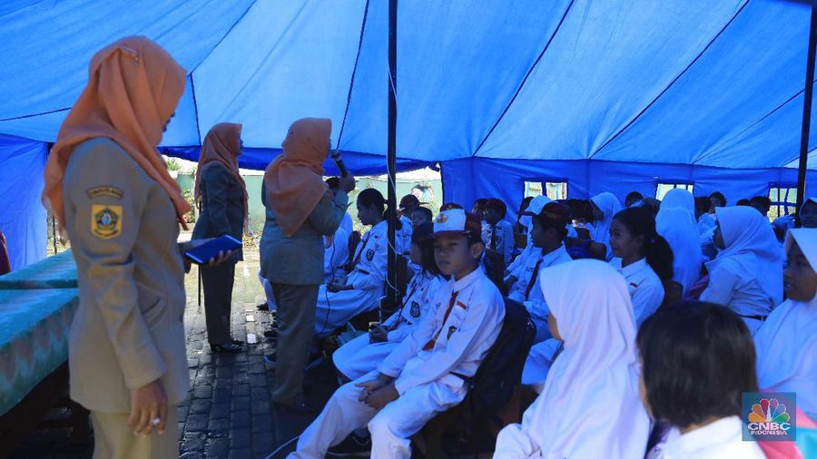 Siswa beraktifitas belaja dengan beratap tenda di Sekolah Dasar Negeri (SDN) Cirimekar 02 Cibinong, Kabupaten Bogor, Jawa Barat, Senin (6/1/2020). Sekolah tersebut rusak berat akibat hujan yang mengguyur wilayah Jabodetabek pada 31 Desember 2019 hingga 1 Januari 2020. Pantauan CNBC Indonesia ada lima ruang yang atapnya ambruk dihantam derasnya air hujan. Tiga ruang kelas, satu ruang guru, dan satu ruang komputer. (CNBC Indonesia/Muhammad Sabki)