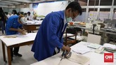 Menggunakan wax paper (kertas yang berbahan lilin) yang berfungsi melapisi tulisan agar tidak lengket saat pengeringan menggunakan setrika. (CNNIndonesia/Safir Makki)