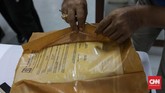 Petugas sangat hati-hati membuka dokumen dari warga yang kondisi masih basah. Membuka perlahan agar tidak sobek menggunkan pinset. (CNNIndonesia/Safir Makki)
