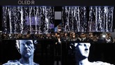 Seorang pengunjung tengah mencoba mengabadikan TV LG OLED di CES 2020. (AP Photo/John Locher)