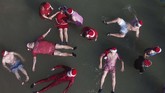 Anggota kelompok Santa Klaus terlatih yang berasal dari negara-negara Eropa dan Amerika Serikat berenang terapung dekat Laut Mati di Jericho, Israel. (AP Photo/Ariel Schalit)