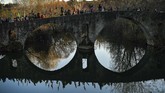 Tiga Raja yang menunggang kuda melambaikan tangan pada orang-orang yang melintas jembatan Magdalena di sungai Arga, di Pamplona, Spanyol bagian utara. (AP Photo/Alvaro Barrientos)
