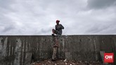 Warga melihat gelombang air laut yang tinggi di kawasan Muara Baru, Jakarta, 9 Januari 2020. Badan Meteorologi, Klimatologi, dan Geofisika (BMKG) memperkirakan daerah pesisir Jakarta Utara mengalami air pasang maksimum pada 9 Januari hingga 11 Januari 2020. (CNNIndonesia/Safir Makki)