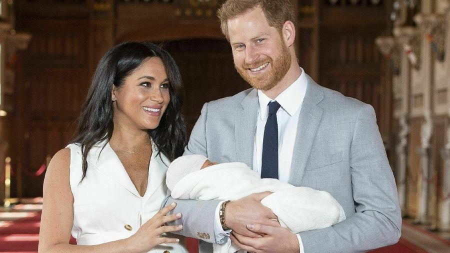 FILE - In this Wednesday May 8, 2019 file photo, Britain's Prince Harry and Meghan, Duchess of Sussex, during a photocall with their newborn son Archie, in St George's Hall at Windsor Castle, Windsor, south England. In a stunning declaration, Britain’s Prince Harry and his wife, Meghan, said they are planning “to step back†as senior members of the royal family and “work to become financially independent.†A statement issued by the couple Wednesday, Jan. 8, 2020 also said they intend to “balance†their time between the U.K. and North America (Dominic Lipinski/Pool via AP, file)