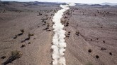 Kepulan asap dari suatu mobil balapan terlihat di gurun ketika diselenggarakannya Reli Dakar di Al Wajh, Arab Saudi. (AP Photo/Bernat Armangue)