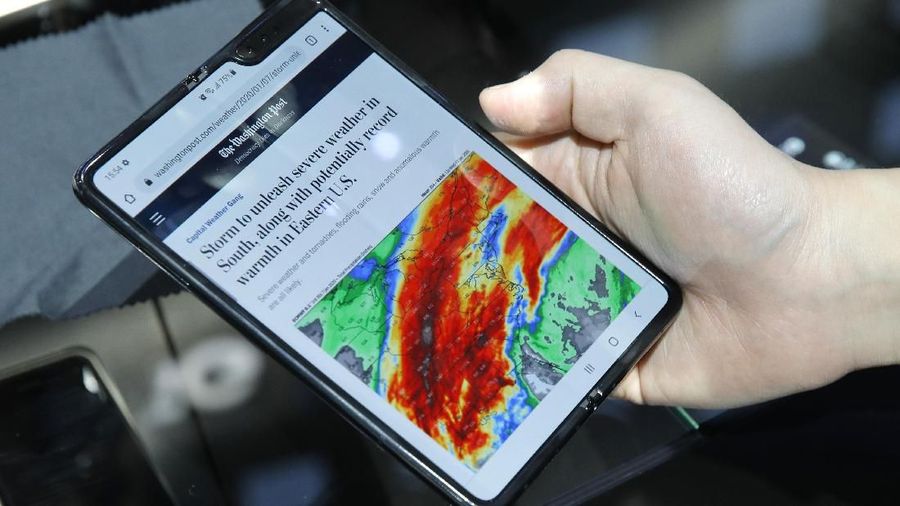 An attendee holds a Galaxy Fold 5G phone at the Samsung booth during the CES tech show, Tuesday, Jan. 7, 2020, in Las Vegas. (AP Photo/John Locher)