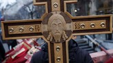 Seorang pria memegang salib pada suatu aksi di Belgrade, Serbia, untuk memprotes pengekangan kebebasan beragama di negara-negara tetangga Serbia. (AP Photo/Darko Vojinovic)