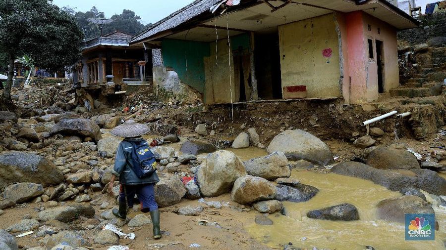 Aktivitas warga di Kampung Adat Urug di Desa Urug, Kecamatan Sukajaya, Kabupaten Bogor, Jumat (10/1/2020). Banyak rumah-rumah luluh lantak diterjang banjir bandang. Batu gunung berukuran raksasa masuk ke rumah-rumah sehingga warga terpaksa pindah ke kerabat. Ketua Adat Kampung Urug, Abah Ukat Raja Aya menceritakan, banjir kala itu terjadi dua kali. Namun, banjir kedua lah yang sangat besar dan merusak pemukiman, meski tidak menimbulkan korban jiwa. Abah sendiri tidak mengetahui pasti berapa banyak rumah yang rusak dan jumlah warga yang harus mengungsi atau pindah ke rumah saudaranya. Bahkan, pengungsian pun tidak ada. Menurut Kepala adat disini kampung ini butuh seragam seragam sekolah dan buku-buku tulis. Selain itu, di kampung ini pasokan beras masih minim karena tidak ada yang mengantar. Meski jalur ke kampung ini sudah dibuka namun ada beberapa jalan menuju kampung ini masih susah. Kondisi listrik pun di kampung ini belum mati total. Warga Kampung urug ini mayoritas warganya bertani. Beberapa petani disini juga merasa kerugian karena banyak hasil panennya terendam banjir bandang.  (CNBC Indonesia/Muhammad Sabki)