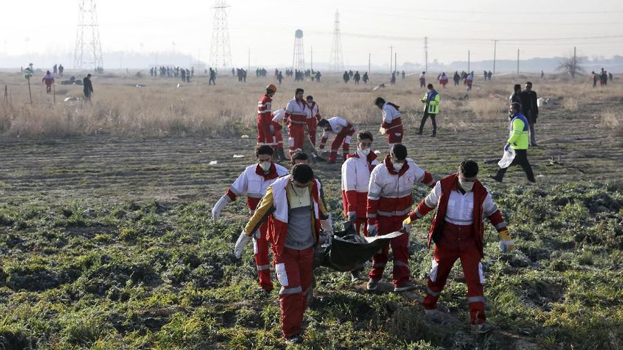Rescue workers recover the bodies of victims of a Ukrainian plane crash in Shahedshahr, southwest of the capital Tehran, Iran, Wednesday, Jan. 8, 2020. A Ukrainian airplane carrying over 170 people crashed on Wednesday shortly after takeoff from Tehran's main airport, killing all onboard. (AP Photo/Ebrahim Noroozi)