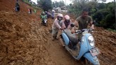 Sebanyak 11 desa di Kecamatan Sukajaya sempat terisolir akibat banjir bandang dan tanah longsor. Tampak warga melewati tebalnya lumpur dan tanah yang menutupi jalan. (ANTARA FOTO/Yulius Satria Wijaya/pd.)